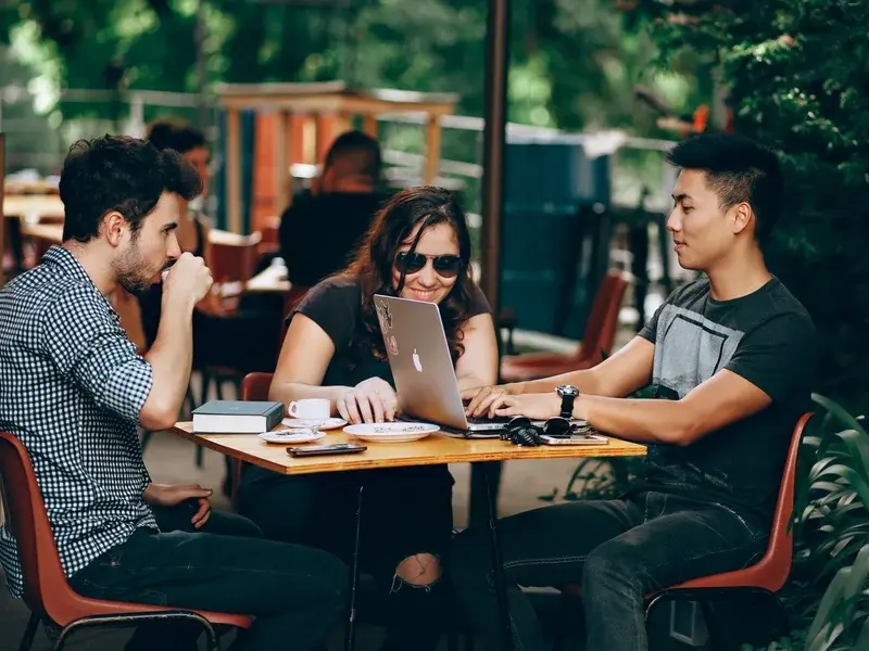 People at a table with a laptop